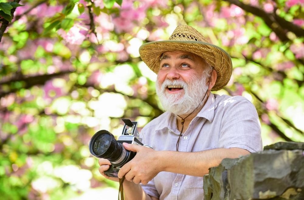 photography benefits for Alzheimer's senior man with camera outside happy