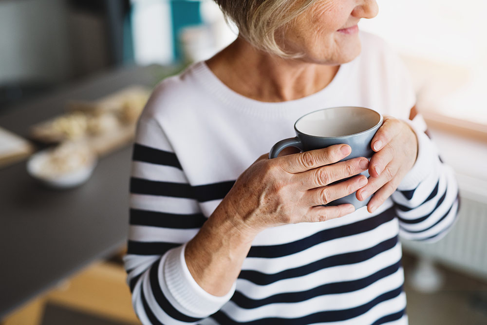 Sabal-Palms-senior-woman-drinking-tea-coffee-holding-mug