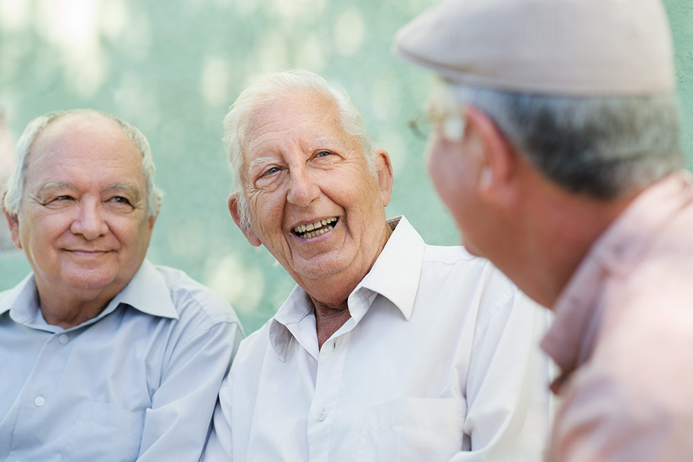 Senior men sitting and talking, socializing, at assisting living community