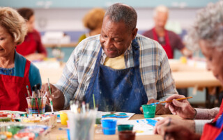 A senior man takes a painting class