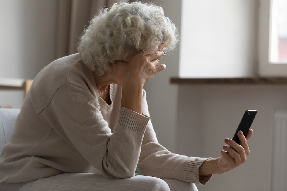 A senior woman stressed after a scam phone call