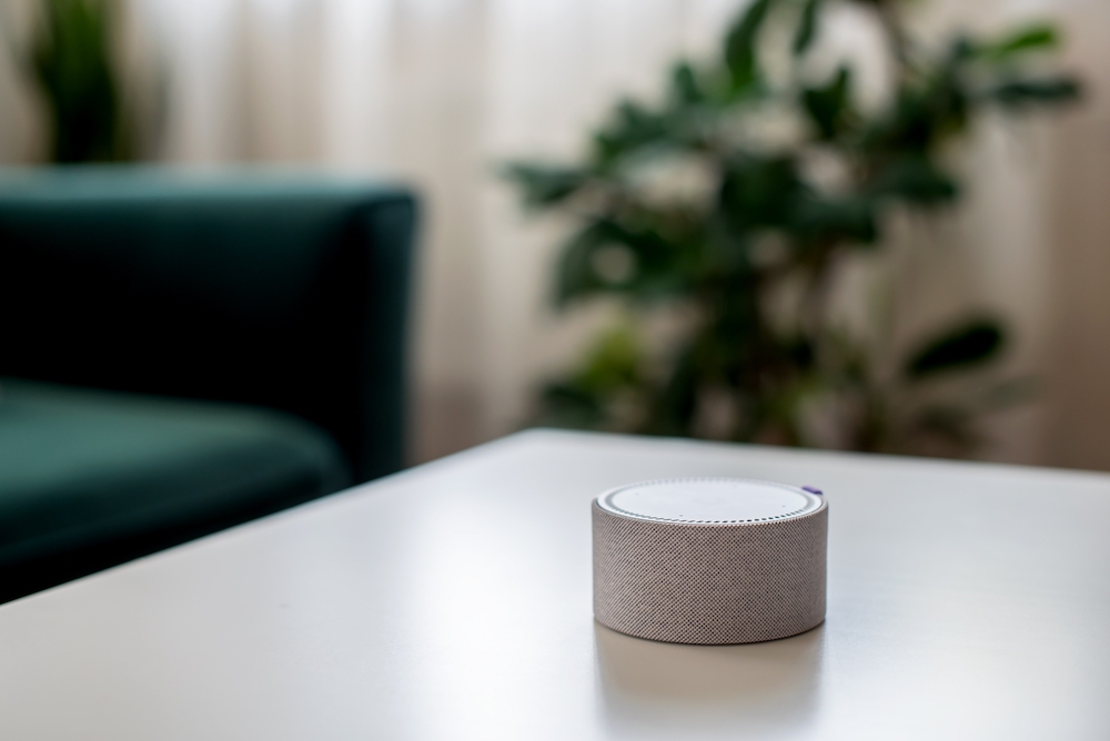 A digital assistant sits on a coffee table in a living room at senior assisted living apartments