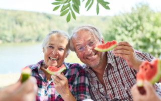 A happy senior couple eats watermelon together