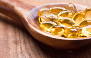 Fish oil pills sitting on a wooden spoon