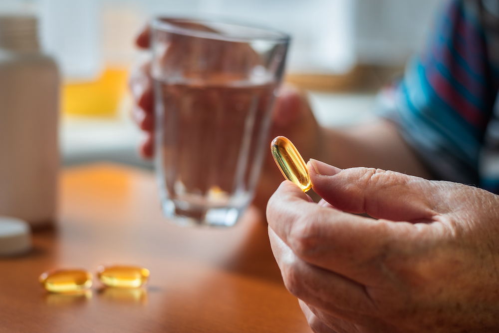A senior man takes a fish oil vitamin