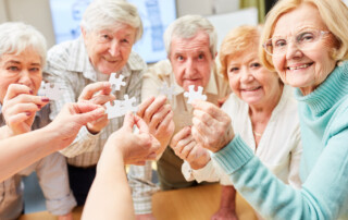 Residents of one of the luxury memory care communities in FL hold up puzzle pieces